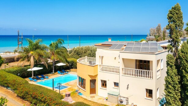 A two-story building with a swimming pool, solar panels, and a view of the sea. - Villa Tsikkos Ena - Three Bedroom Villa, Sleeps 6 (Argaka)