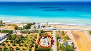 An aerial view of a coastal area with a house circled, surrounded by greenery and a road. - Villa Tsikkos Ena - Three Bedroom Villa, Sleeps 6 (Argaka)