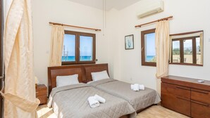 A bedroom with a bed, a dresser, and two windows with curtains. - Villa Tsikkos Ena - Three Bedroom Villa, Sleeps 6 (Argaka)