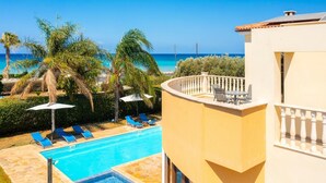 A pool area with blue lounge chairs, a small pool, and a view of the ocean. - Villa Tsikkos Ena - Three Bedroom Villa, Sleeps 6 (Argaka)