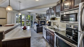 A modern kitchen with a large island, built-in oven, and a dishwasher. - Woodbridge Condos by Snowmass Vacations (Snowmass Village)