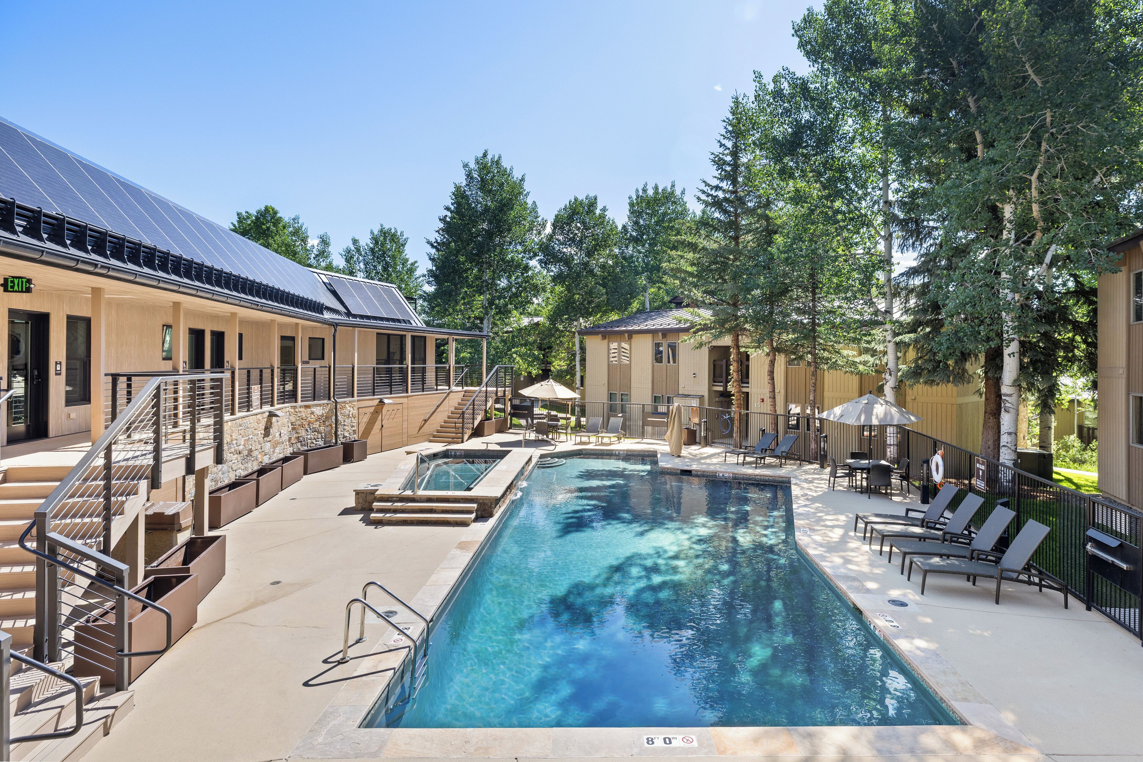 A swimming pool with lounge chairs and a staircase leading to an upper level.