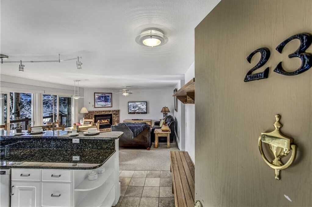 A modern kitchen with a granite countertop, white cabinetry, and a built-in stove.
