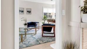 A modern living room with a blue sofa, a coffee table, and a fireplace. - Benelo | Midcentury Modern Single-Level Home, 3 BR (Sioux Falls)