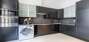 Enjoy cooking in this kitchen with sleek cabinetry, double oven, and washing machine.