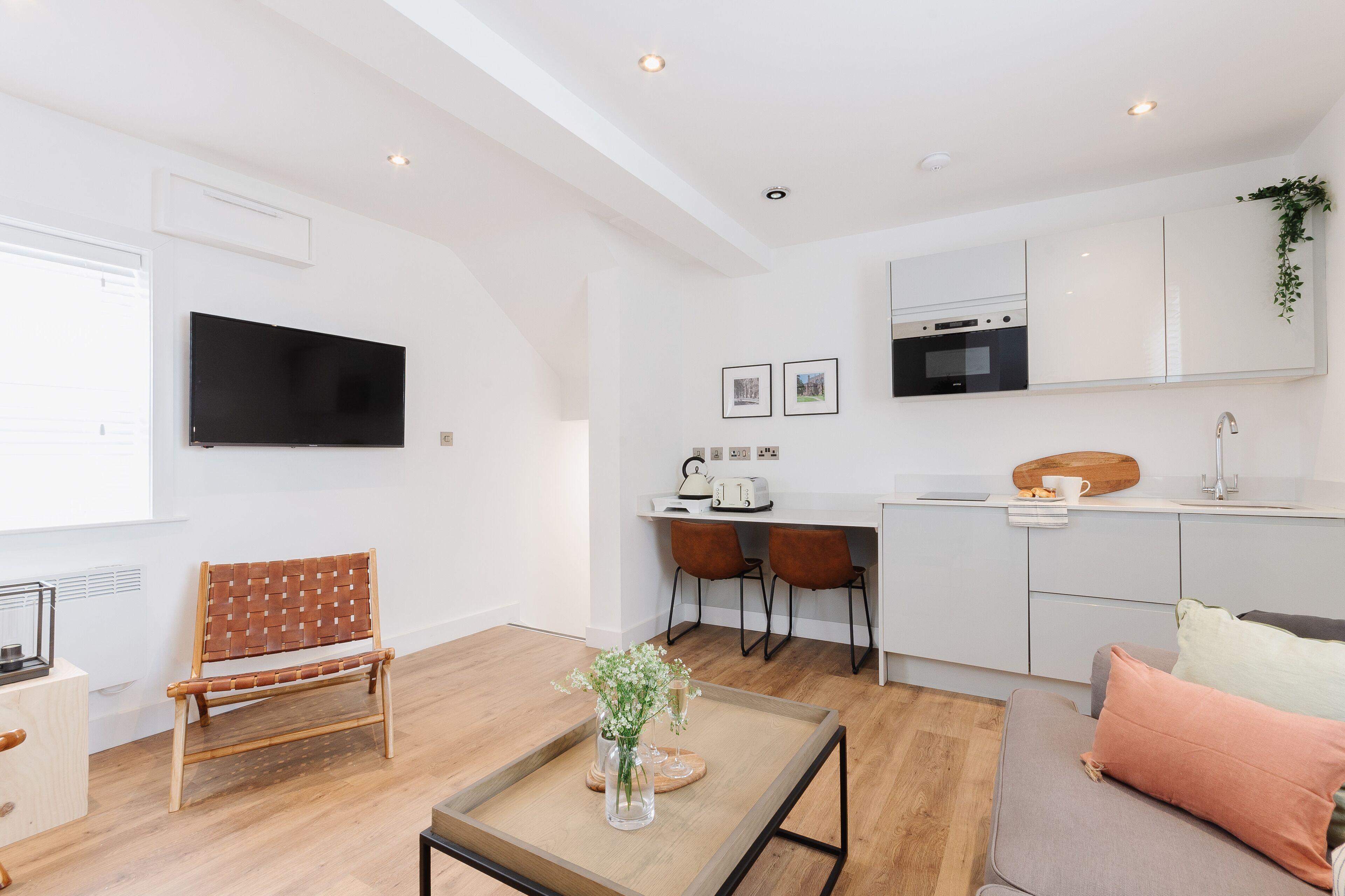 A modern apartment with a living room, dining area, and kitchen.