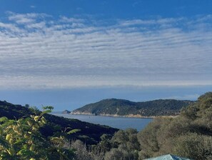 Un paisaje costero con cielo despejado, colinas y una masa de agua.