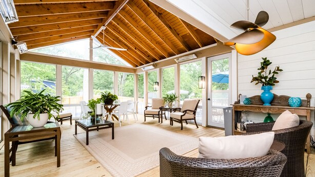 A spacious sunroom with wooden floors, large windows, wicker furniture, and a ceiling fan. - (2027 OPEN!) Gorgeous Grand Beach Home With Private Pool! (Grand Beach)