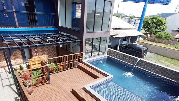 Un espace piscine aménagé sur le toit, avec des chaises longues bleues, une petite piscine et un réservoir d’eau.
