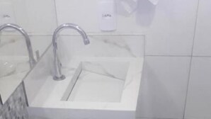 Une salle de bain avec un lavabo blanc, des toilettes et un bidet.