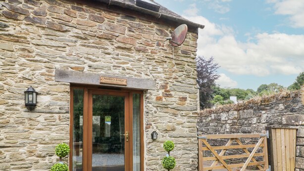 A stone building with a wooden door labeled "Miller's Lodge". - Miller's Lodge (Liskeard)