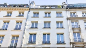A row of classic European-style buildings with uniform window designs and balconies. - Palais Royal – Musée du Louvre (line 1 and line 7), Pyramides & Bourse (line 3). (Paris)
