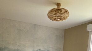 A bedroom with a bed, pillows, a nightstand, a lamp, a wall mural, and a window. - 6/8 person gîte with swimming pool and jacuzzi (Thésée)