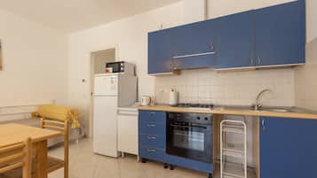 Standard Apartment Daphne | Private kitchen | Full-sized fridge, microwave, cleaning supplies