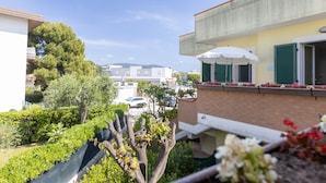 Balcón residencial con vista a un estacionamiento y edificios al fondo.