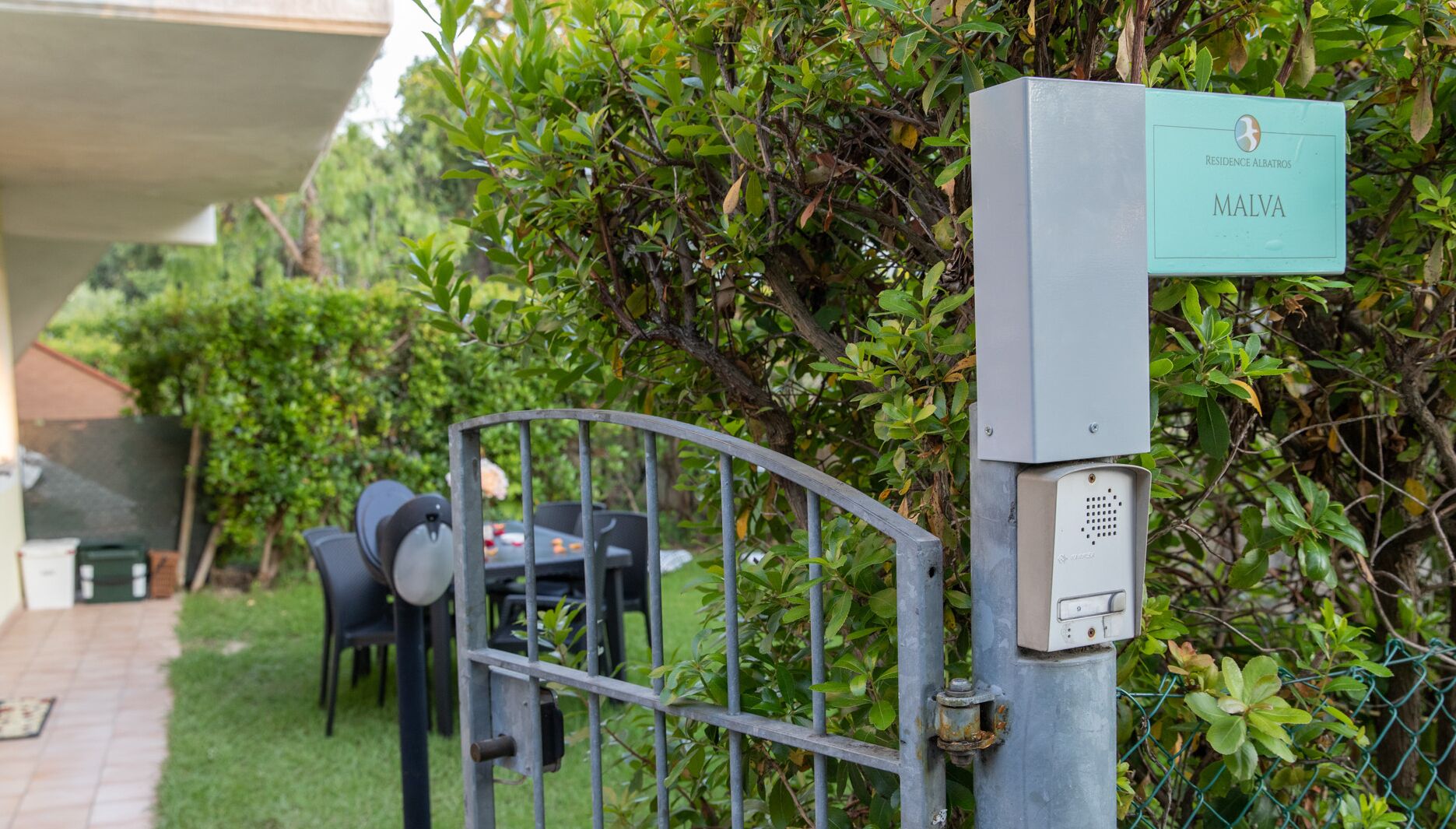 A gated entrance with a sign indicating 'Residence Albatros Malva'.