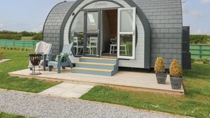 Un bâtiment moderne, de forme semi-circulaire, doté d’une grande porte ouverte et d’un petit espace porche.