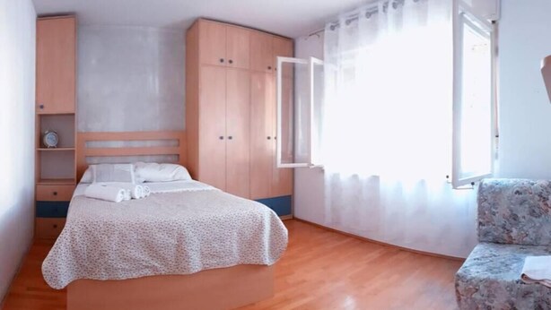 A bedroom with a bed, a wardrobe, a chair, and a window. - 3 minutes to the Diocletian's Palace! Two bedroom cosy apartment (Split)