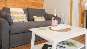 Un salon chaleureux avec un canapé gris, une table basse blanche et une bouteille de champagne Moët.