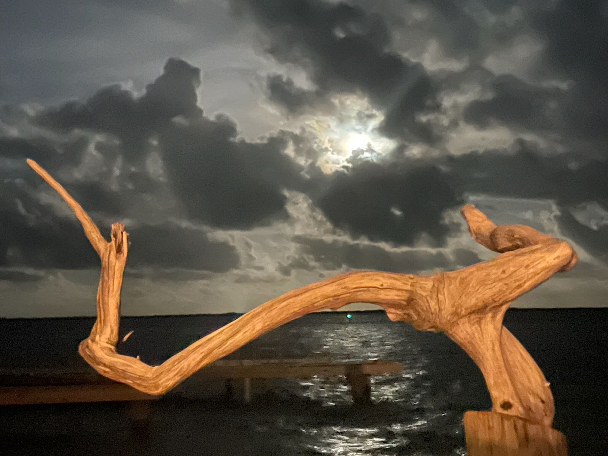 Una escultura de madera al pie de un cielo tormentoso.