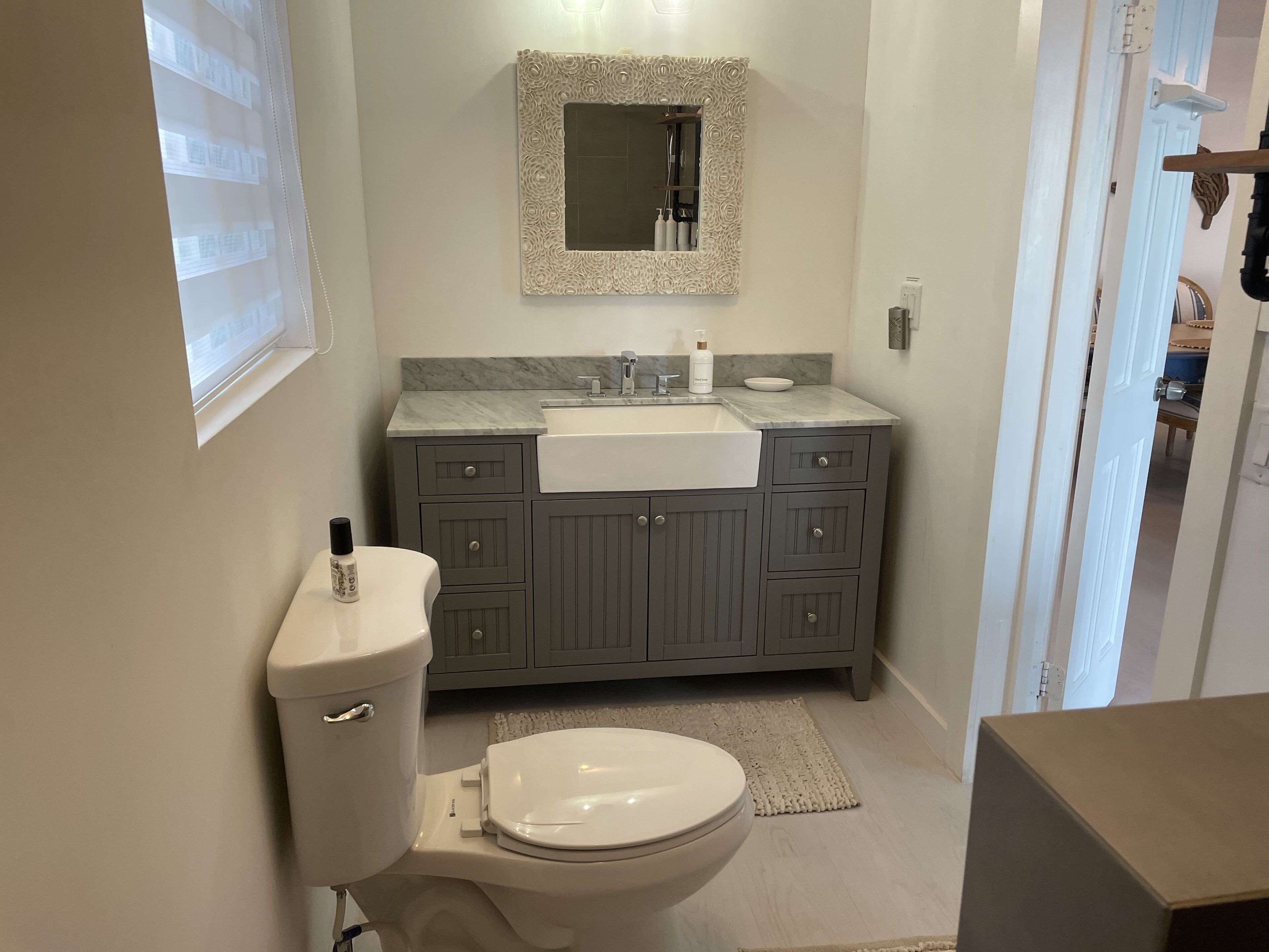 Une salle de bain avec des toilettes, un lavabo et un miroir.