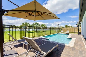 A poolside area with a view of a fenced lawn, a pool, and lounge chairs. - ✸NEW✸ 6BR, 500 steps to the beach, Private Pool, Game Room (Melbourne)