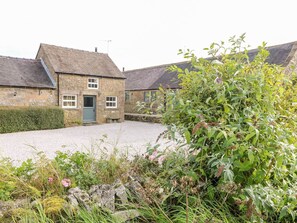 A stone house with a gravel driveway and a garden in front. - The Dairy (Bakewell)