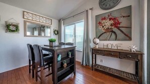 Un comedor con una mesa de madera, sillas, un espejo y un reloj de pared.