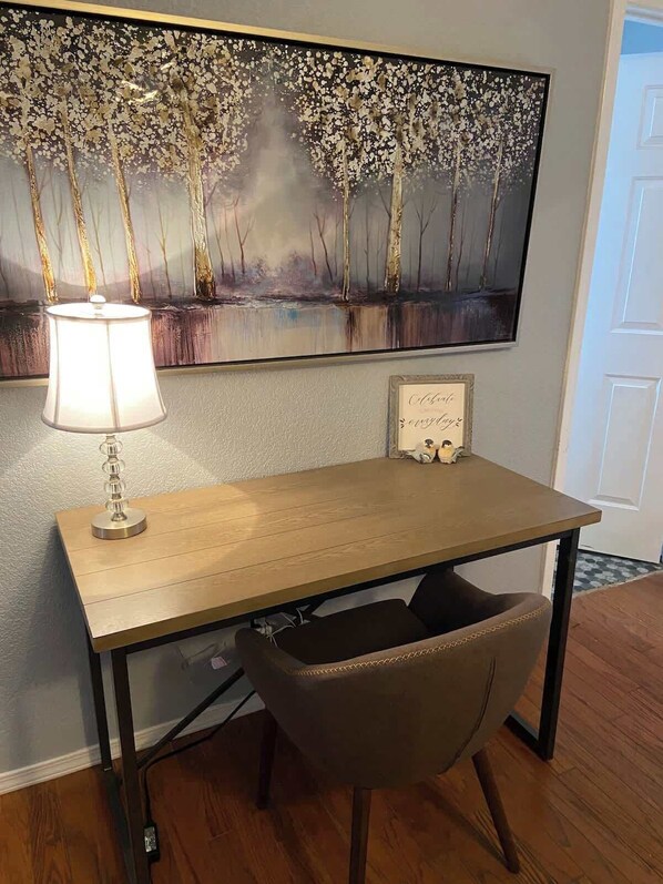 A desk with a lamp, a chair, a framed quote, and a painting on the wall. - Mt View Villa Kingbed Firepit (Flagstaff)