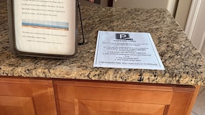 A kitchen counter with a parking pass and a message about checking for stains or damage.