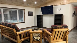 A cozy room with a wooden ceiling, a sofa, a table, and a fireplace. - Rustic hunt club lodge in the heart of Minnesota lakes country... (Ashby)