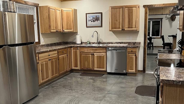 A modern kitchen with wooden cabinets, stainless steel appliances, and a granite countertop. - Rustic hunt club lodge in the heart of Minnesota lakes country... (Ashby)