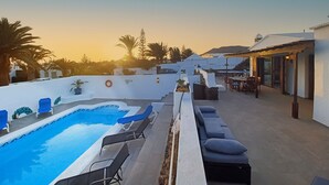 A rooftop pool area with lounge chairs and a view of the sunset. - Villa Magica 7 min walking to center, pool & A/C (Playa Blanca)