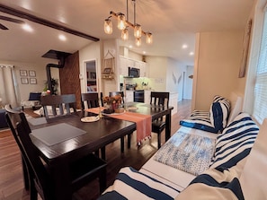 Comedor con una mesa de madera, sillas y una lámpara colgante.