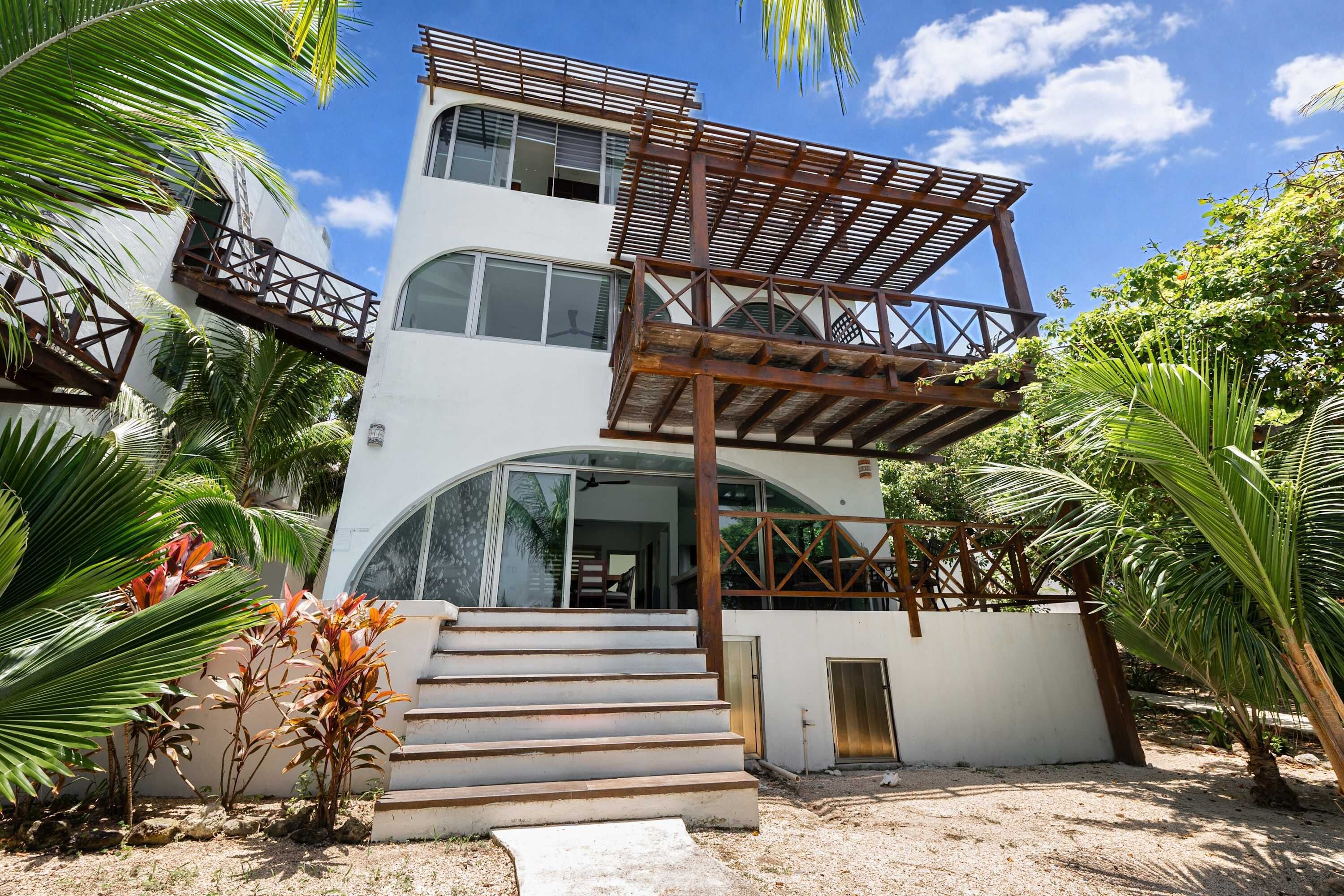 A two-story building with a balcony, a staircase, and a door.