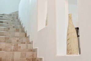 Un escalier avec un mur orné de motifs et un objet décoratif accroché au mur.