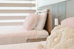 Une chambre avec deux lits, chacun étant équipé d’un oreiller et d’une couverture.