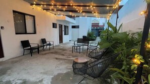 An outdoor patio area with a canopy, string lights, and seating. - Downtown Cancun King Suite | Garden, WiFi & AC (CancÃºn)