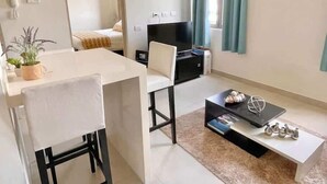 Un salon moderne comprenant un coin repas, un téléviseur et un canapé.