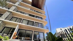 Ein mehrstöckiges Gebäude mit einer zentralen Treppe, Balkonen und einer großen Metallkonstruktion.