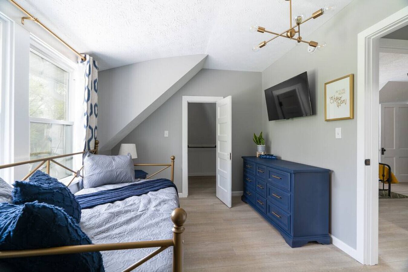 Ein Schlafzimmer mit einem Bett, einem Schminktisch, einem Fernseher und einer Treppe zu einer oberen Ebene.