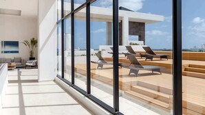Ein modernes Interieur mit großen Fenstern, einem Holzboden und Sitzgelegenheiten im Freien.