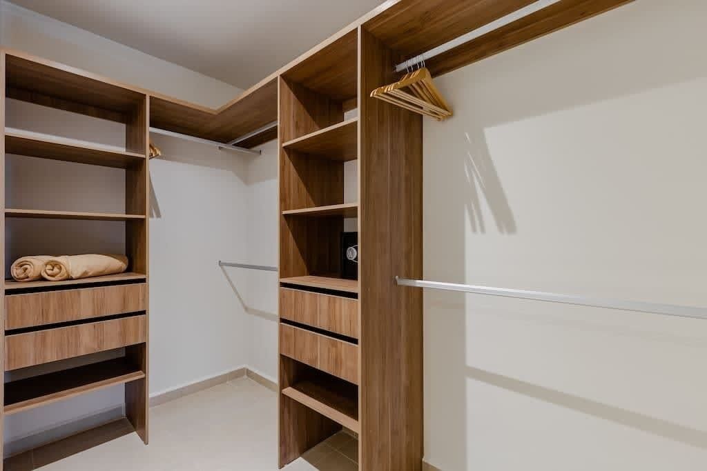 A walk-in closet with multiple wooden shelves and hanging space.