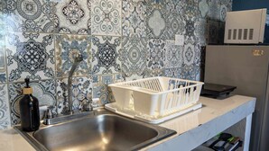 A kitchen with a stainless steel sink, a white dish rack, and patterned tiles. - Central Studio + Rooftop, Downtown Cancun (Cancún)