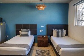 A hotel room with two beds, a nightstand, a unique hanging light fixture, and a window. - Central Studio + Rooftop, Downtown Cancun (Cancún)