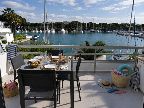 A balcony with a table set for dining, overlooking a marina with boats. - Sol-y-Days la Darse, Apartment Marina Terrace view marina (Le Grau-du-Roi)
