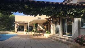 A covered patio area with a pool, outdoor furniture, and potted plants. - In a quiet, hilly setting, bright residence under the pine trees! (La Bouilladisse)