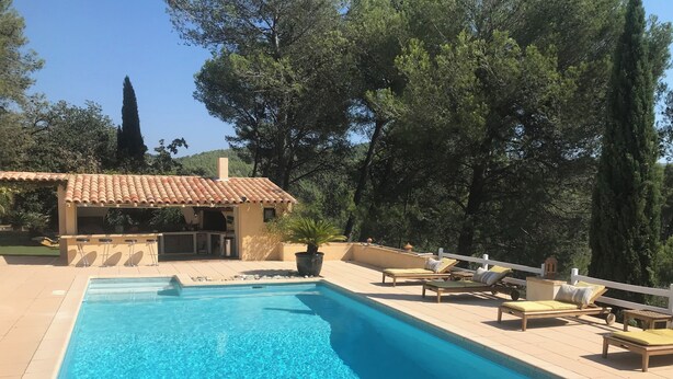 A rectangular swimming pool with a tiled deck, lounge chairs, a small structure with a tiled roof, and surrounding trees. - In a quiet, hilly setting, bright residence under the pine trees! (La Bouilladisse)