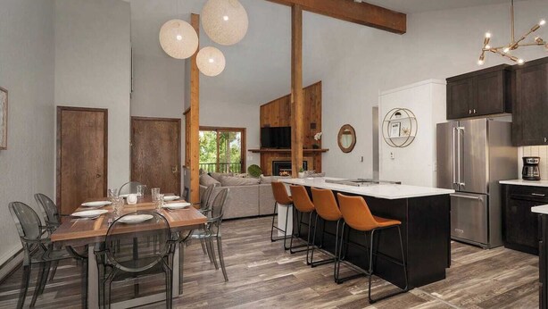 A modern kitchen with a central island, wooden beams, and pendant lighting. - Amazing Views! Downtown Penthouse with Sauna (Winter Park)