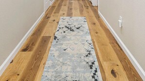 A hallway with wooden flooring, a patterned rug, and white walls. - Tranquil TU Getaway! EXPO/Route 66/Cherry St -3bd (Tulsa)